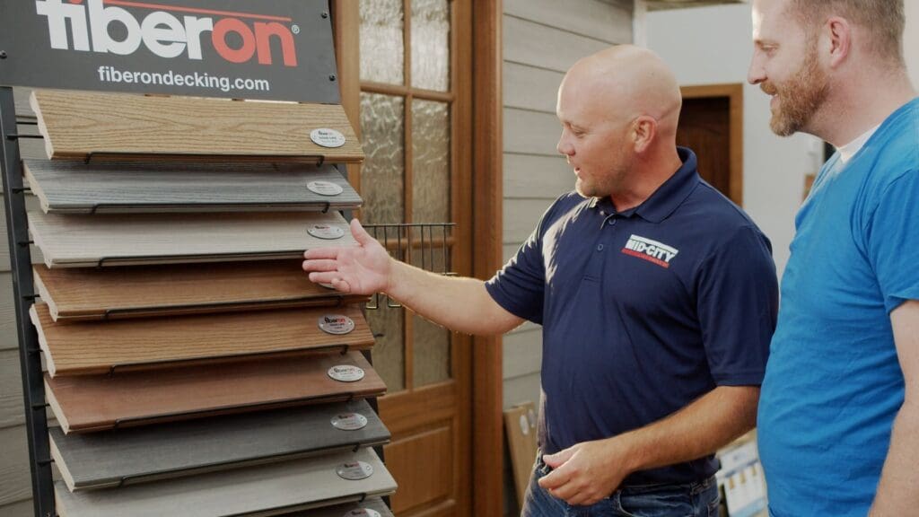 Image of a mid-city employee showing a customer various samples of decking materials.