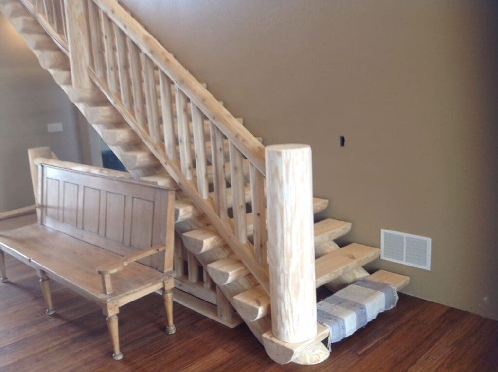 A view of a cabin-like staircase and wooden bench made from unfinished, unpainted lumber