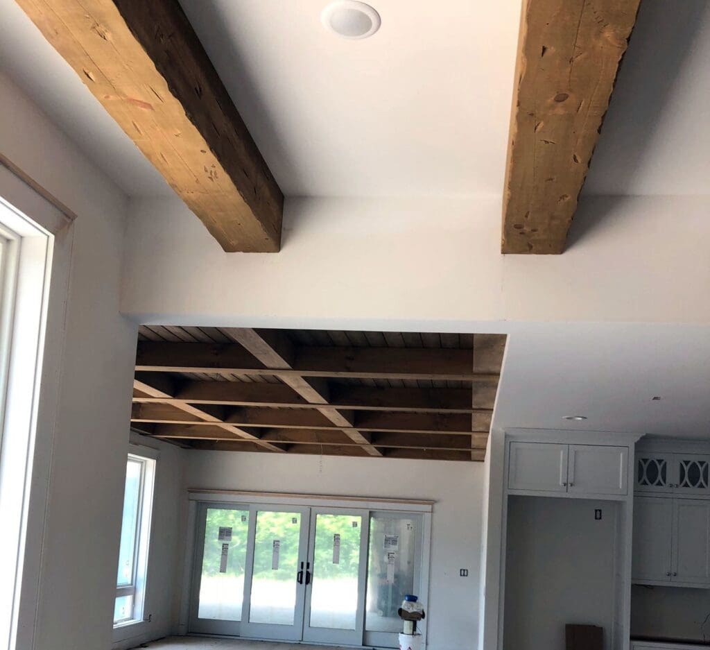 Unpainted wooden beams add character to a white ceiling