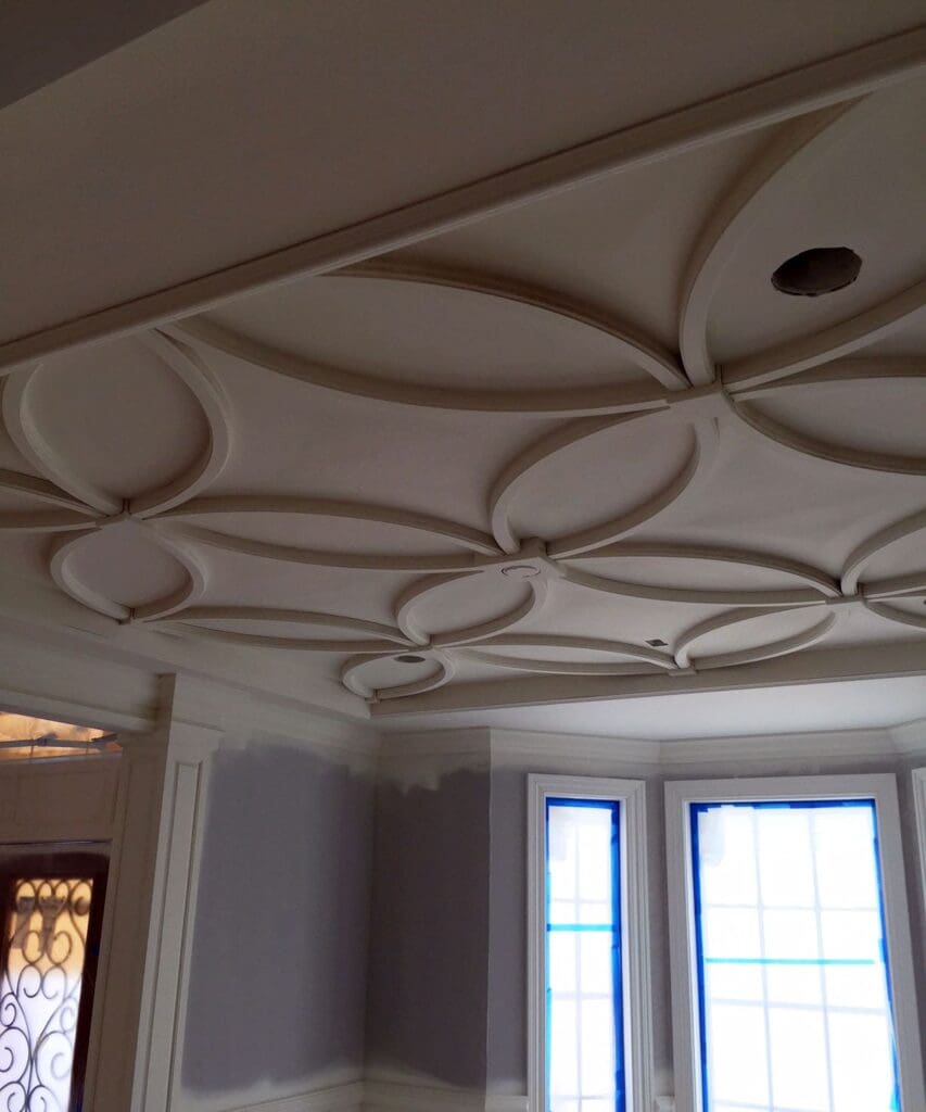 A custom floral pattern has been created from wood pieces that adorn a ceiling